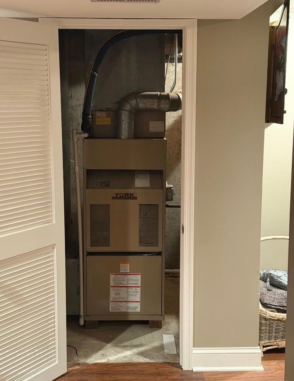 An open doorway reveals a furnace, visible through a decorative white door and inside a utility room.