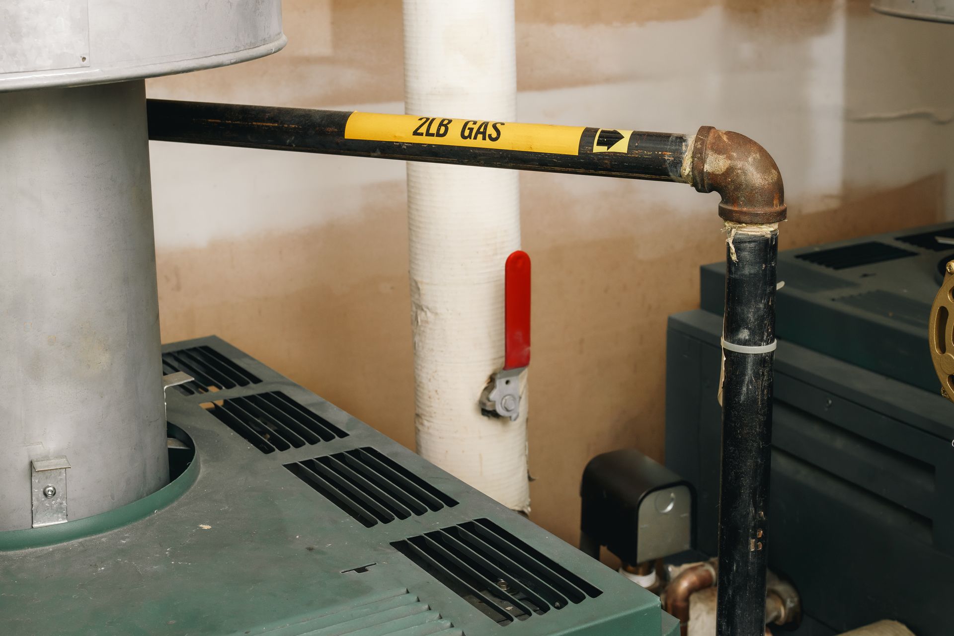 Black gas pipe with a red valve, labeled