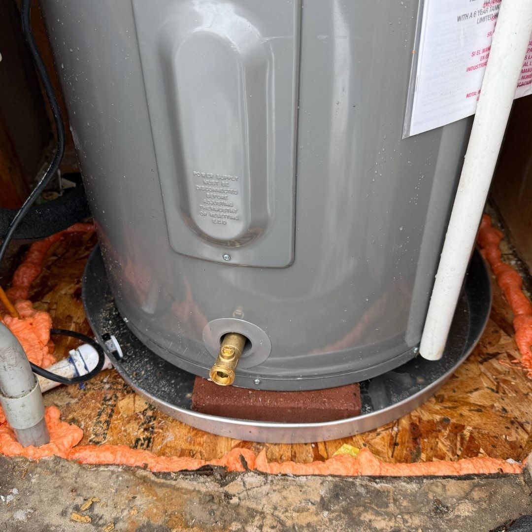 White heating unit and red expansion tank in a basement.