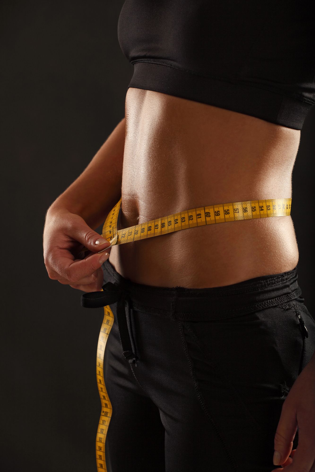 Patient measuring waist during medical weight loss program at Boston Beautox