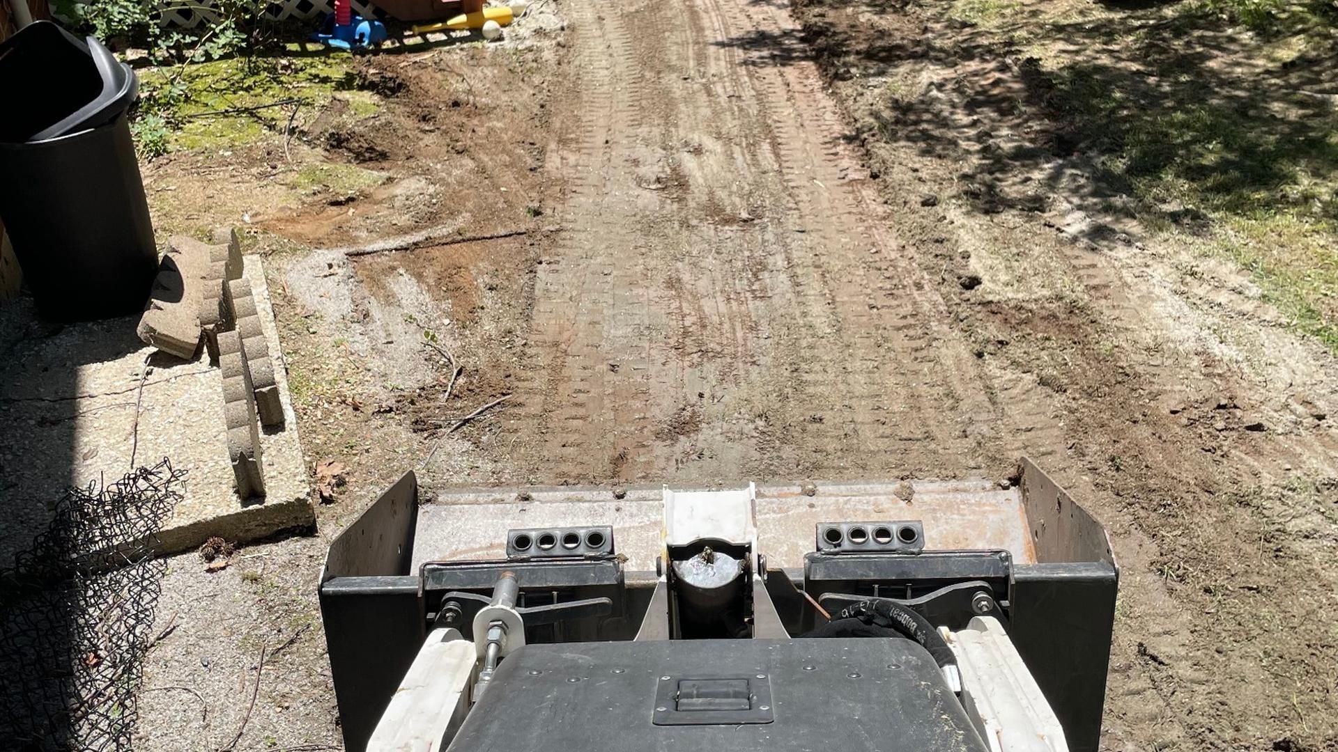 Skid steer preparing a backyard for landscape installation in Chesterfield, VA