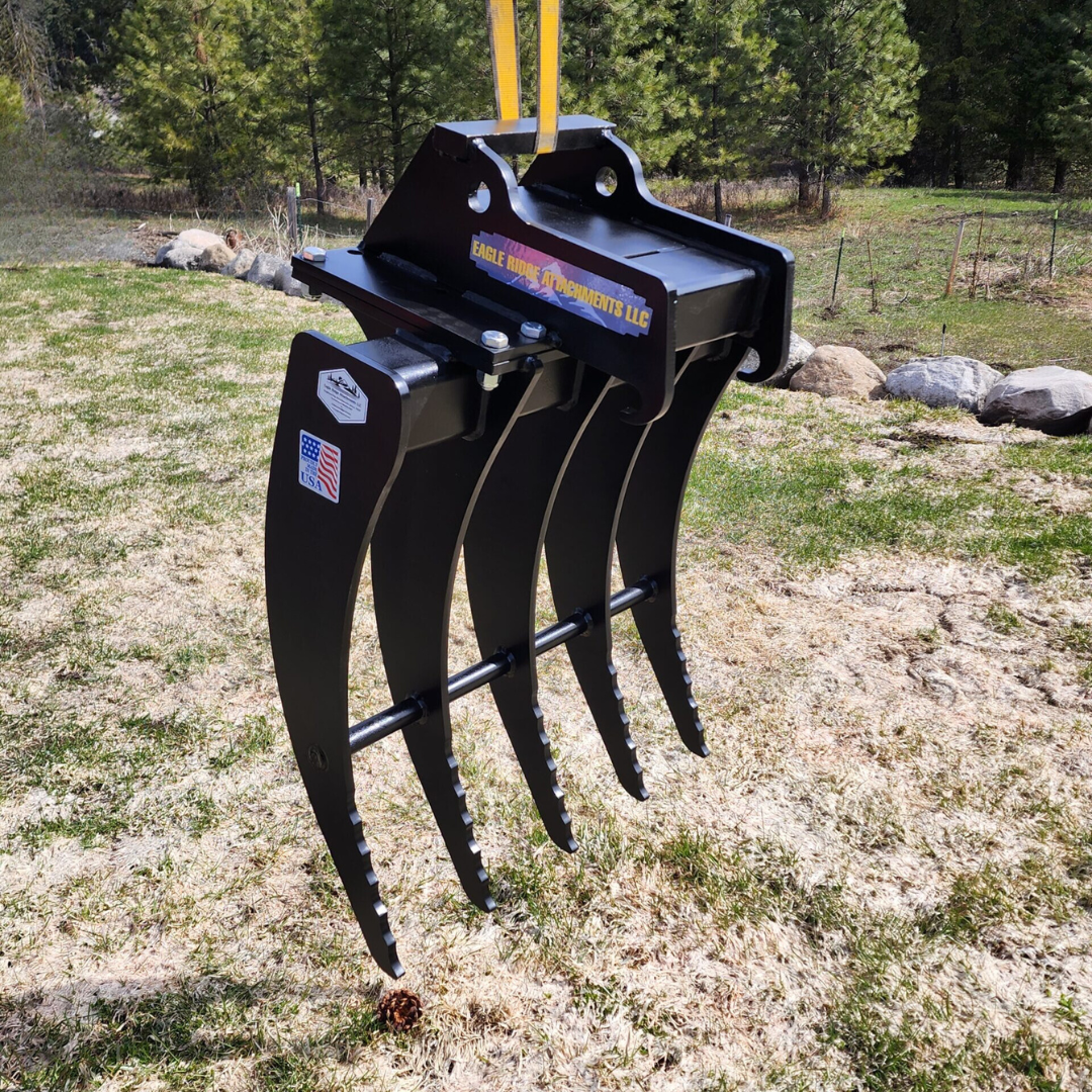 A black rake is sitting on top of a grassy field.
