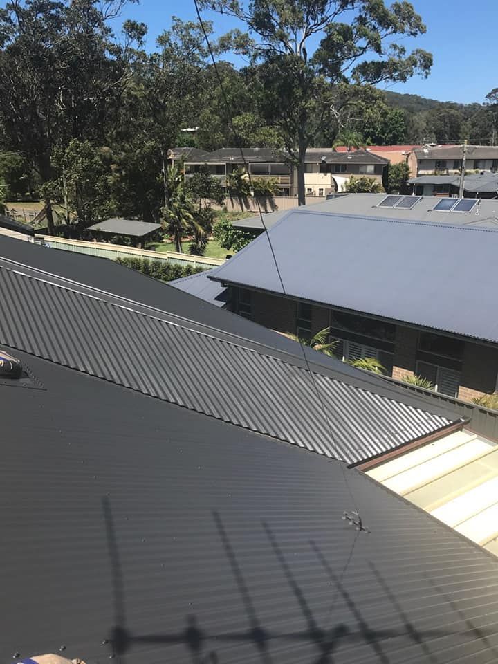 The Roof of a White House With a Blue Sky in the Background — Norwest Roof Restorations In Central Coast, NSW