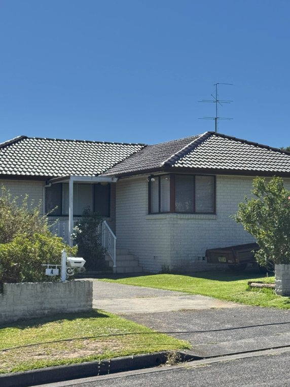 A Man is Working on the Roof of a House — Norwest Roof Restorations In Central Coast, NSW