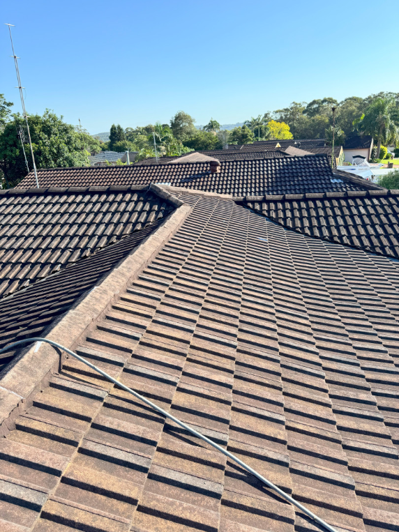 A Construction Worker Is Working On A Metal Roof — Norwest Roof Restorations In Central Coast, NSW