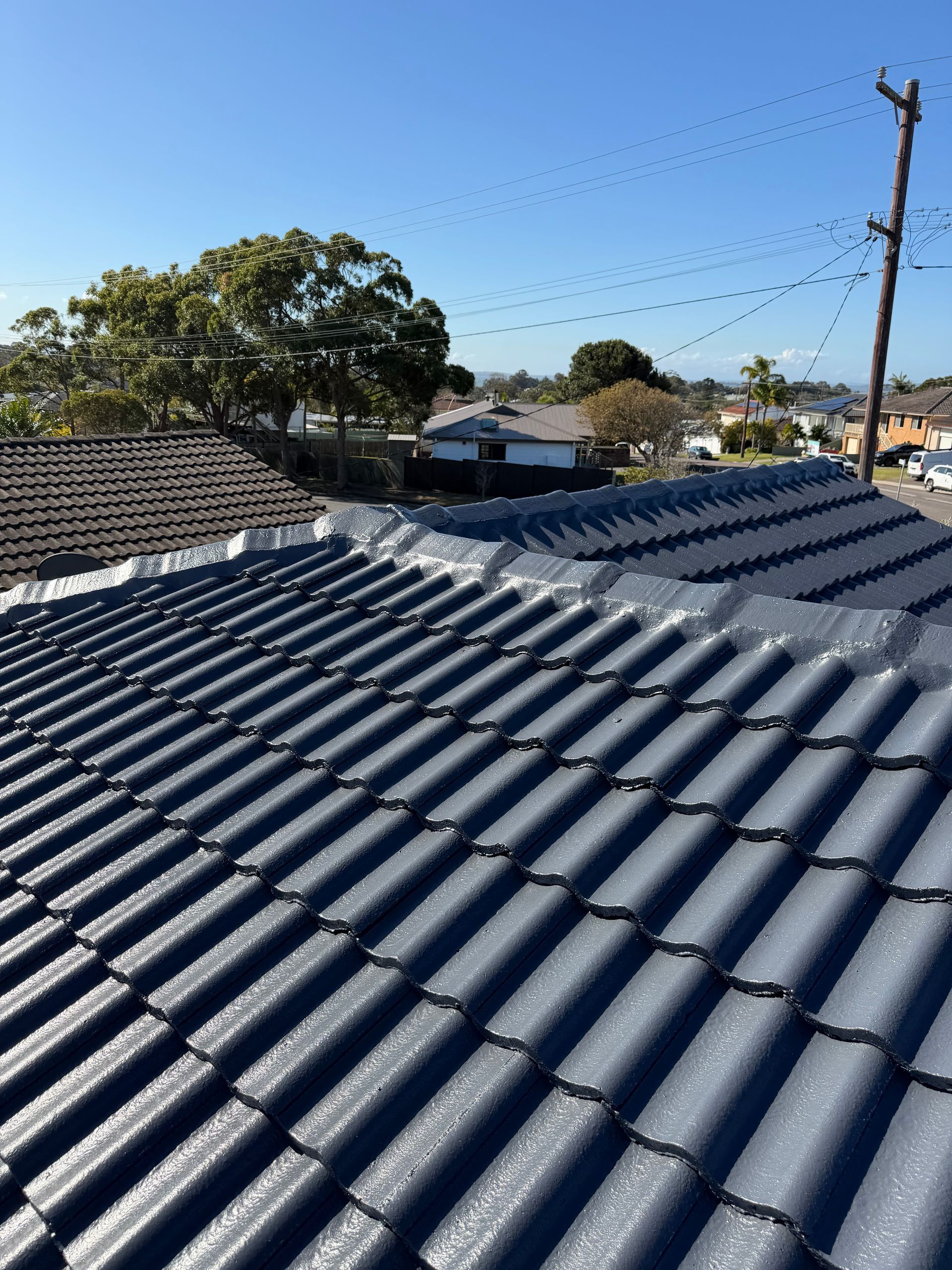 Two Men Are Working on the Roof of a Building — Norwest Roof Restorations In Blue Bay, NSW