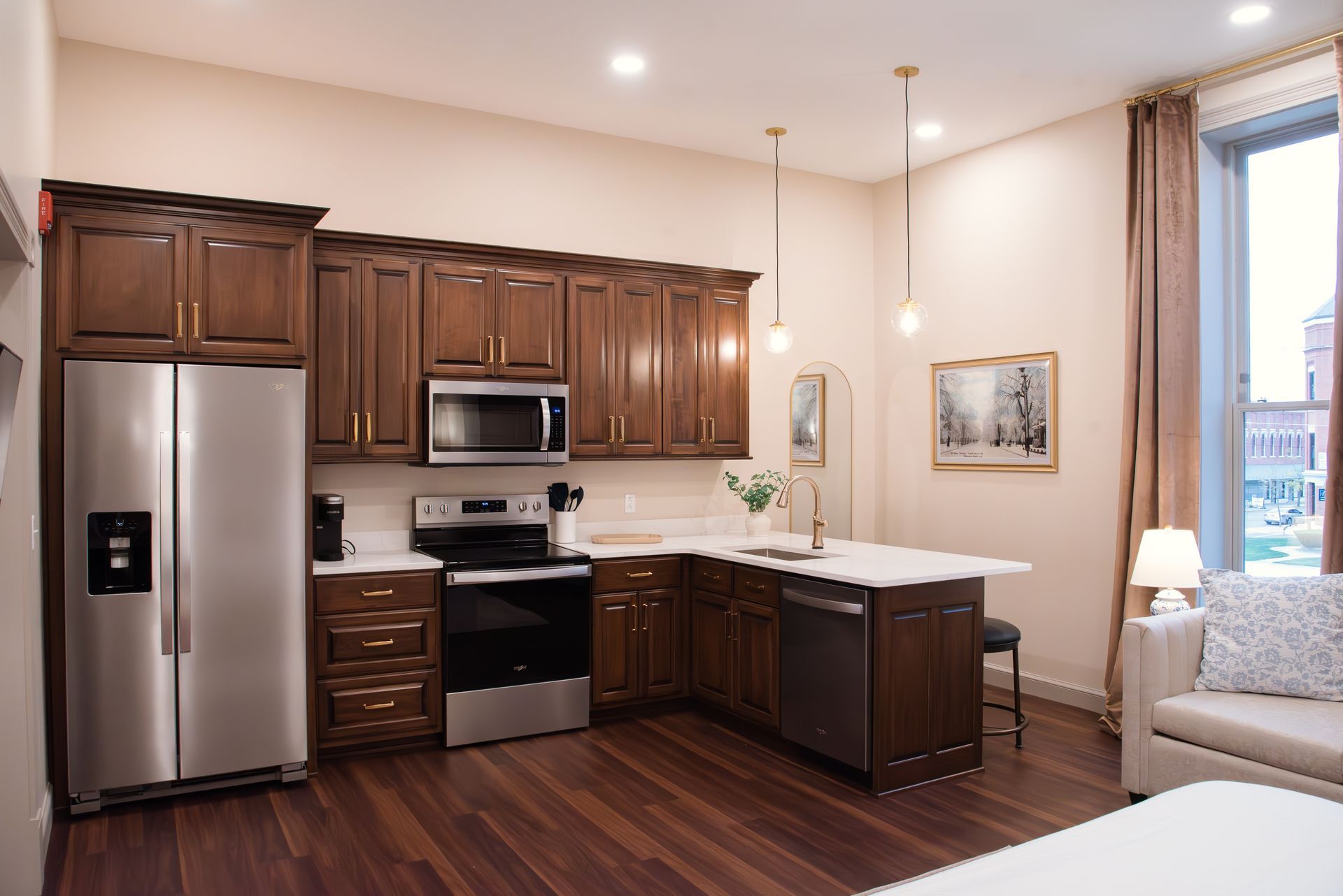 Kitchen with dark wood cabinets, stainless steel appliances, and an island with white countertops.