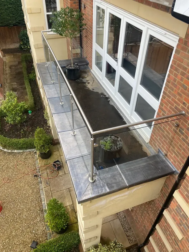 An aerial view of a balcony with a glass railing on a brick building.