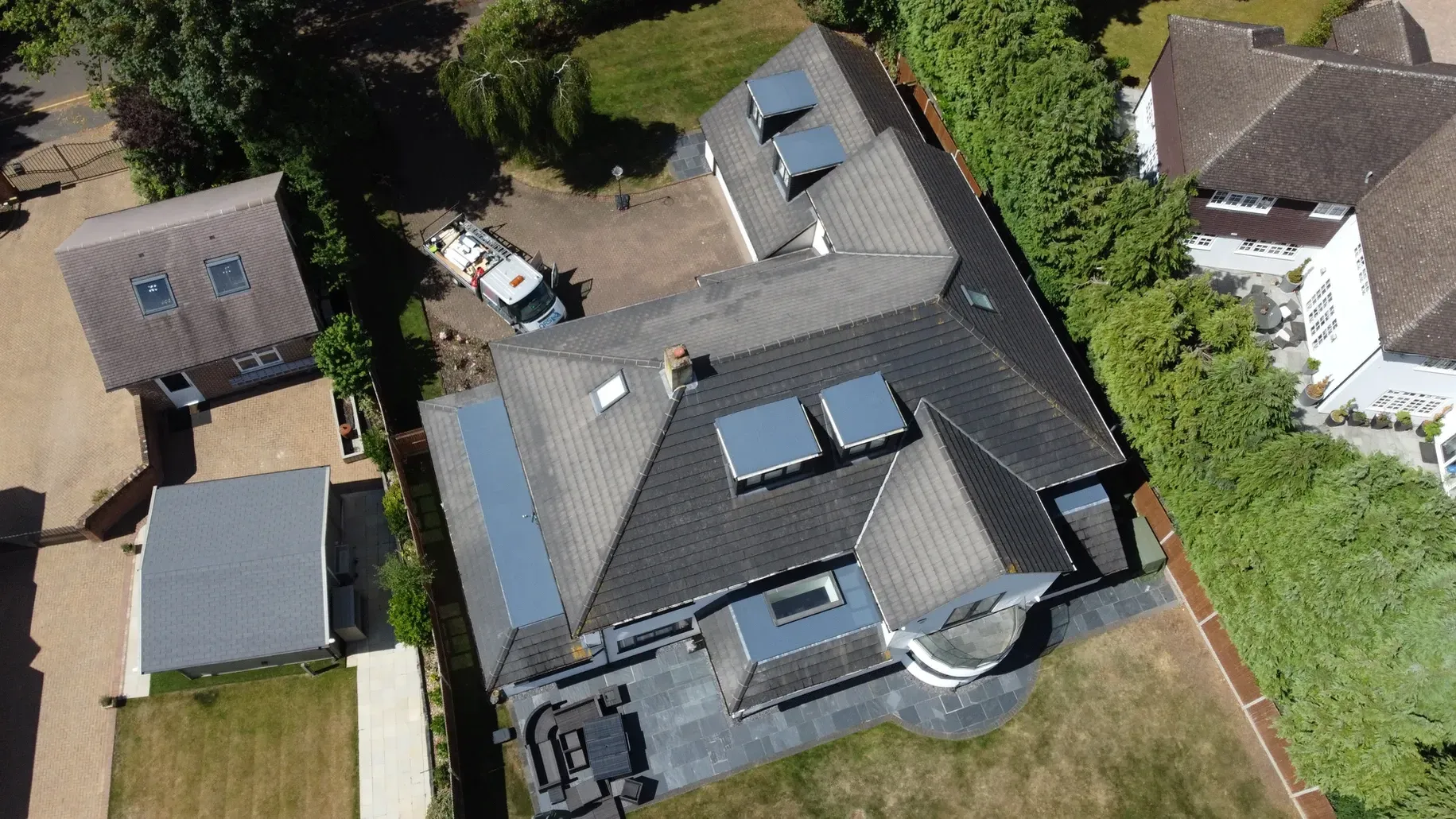 An aerial view of a house with flat roofed windows on the roof