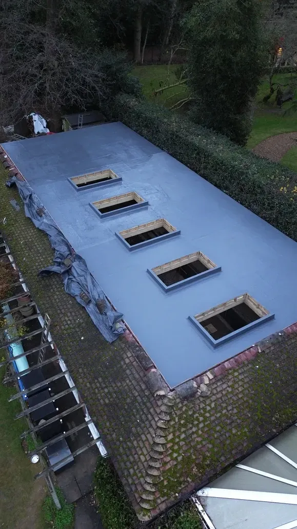An aerial view of a building with a roof that has a lot of windows on it.