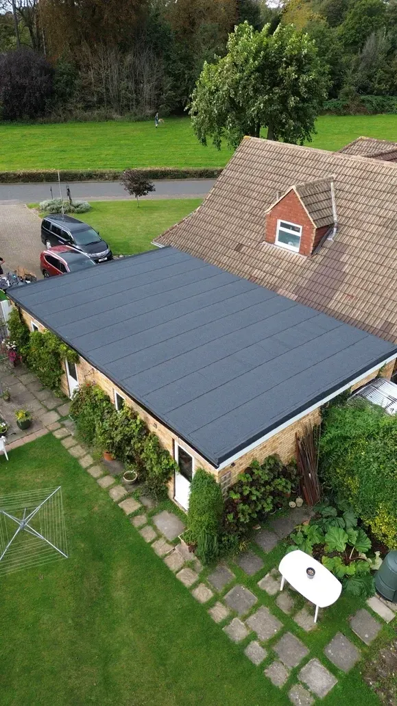 An aerial view of a house with a black felt roof.