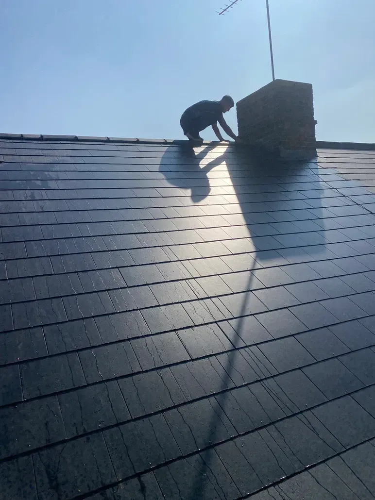 A man is working on the roof of a building.