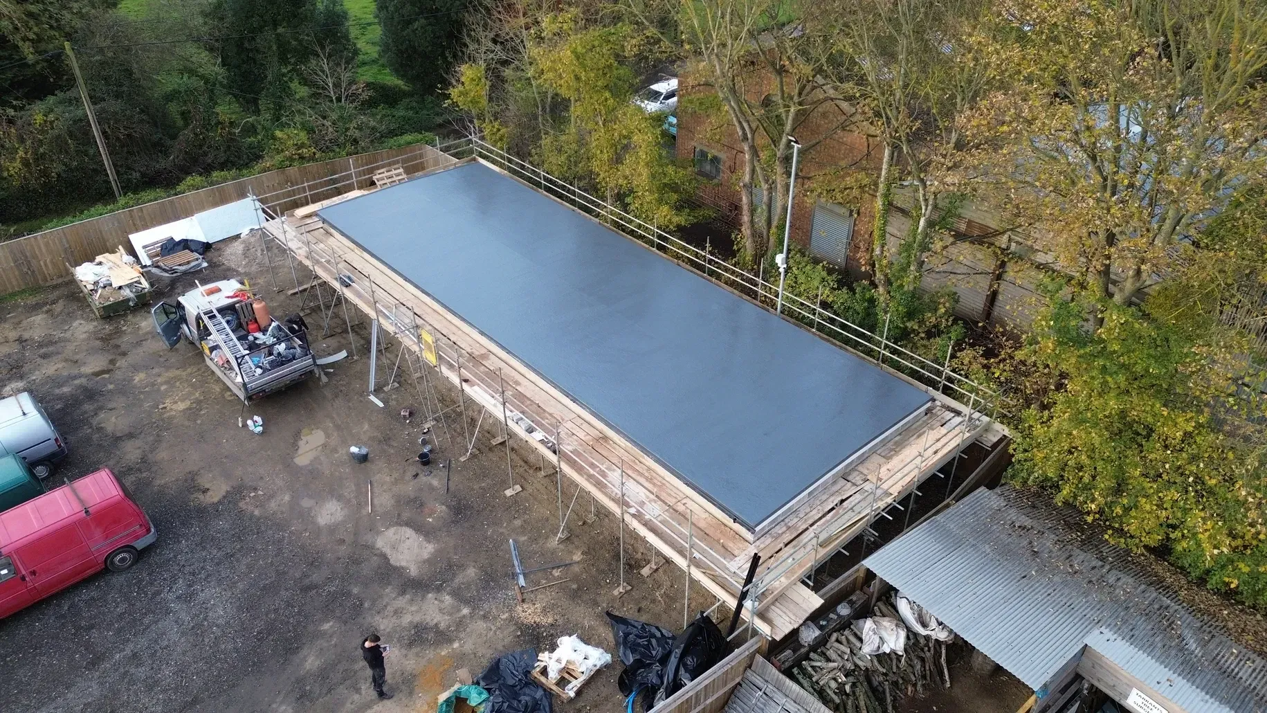 An aerial view of a large flat rubber roof under construction.
