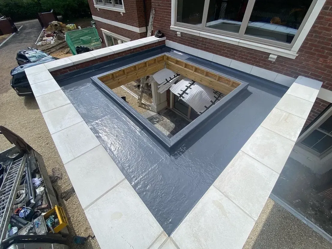 A roof with a hole in it is being built on top of a brick building.