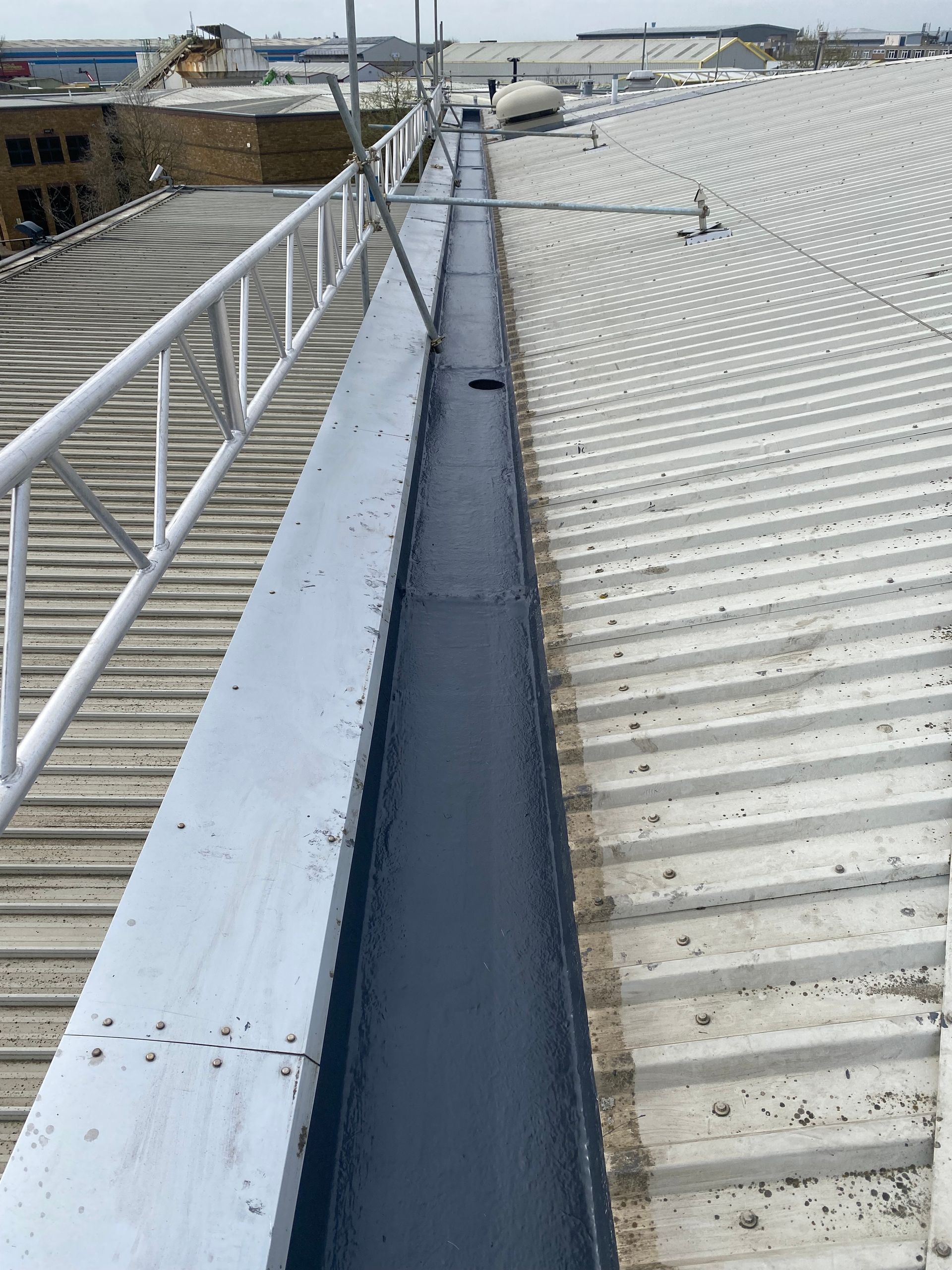 a gutter on the side of a building next to a roof .