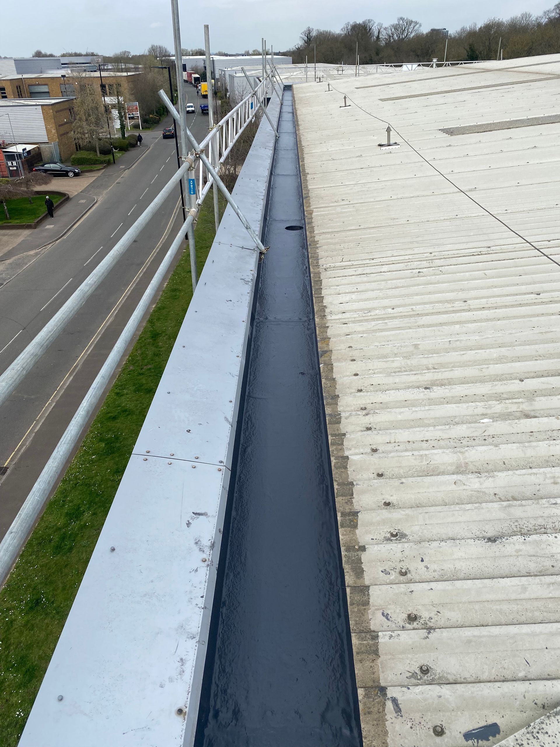 a drain on the side of a building next to a road