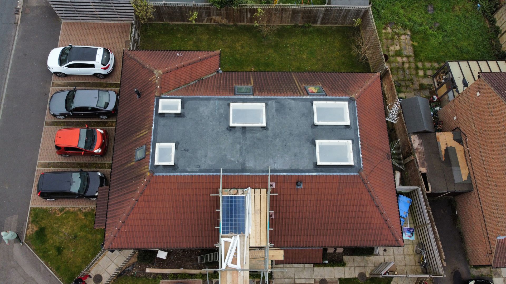 an aerial view of a house with cars parked in front of it .