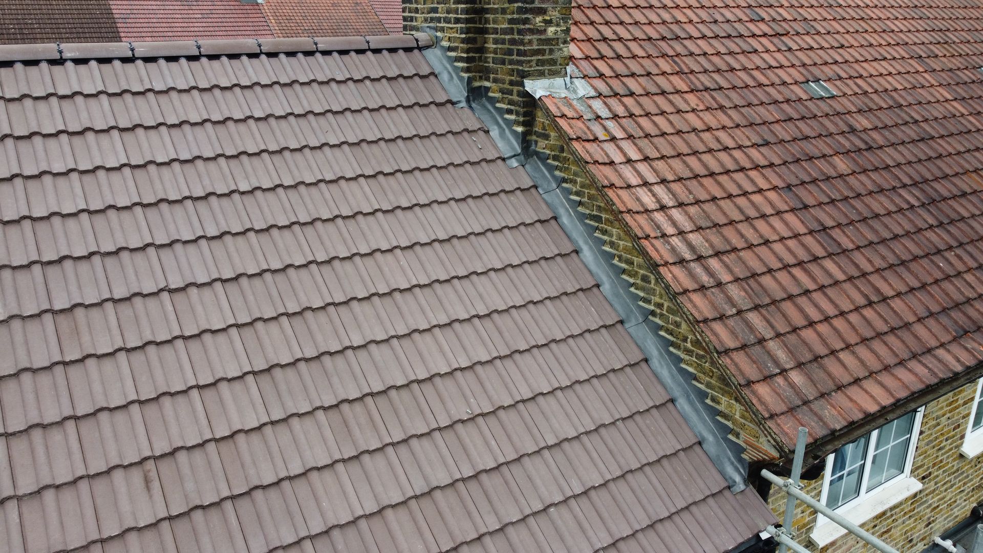 a roof with a lot of tiles on it and a chimney on the side of a house .