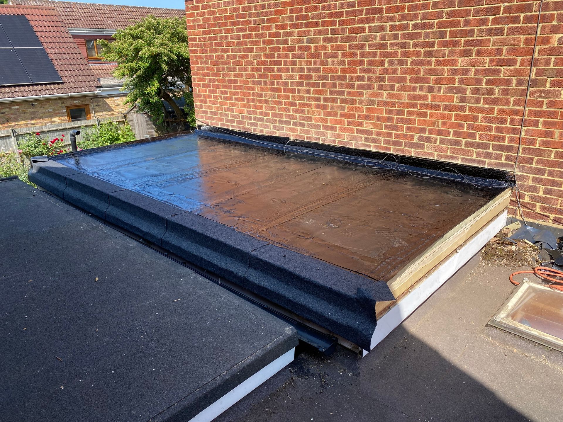 a black flat roof next to a brick building