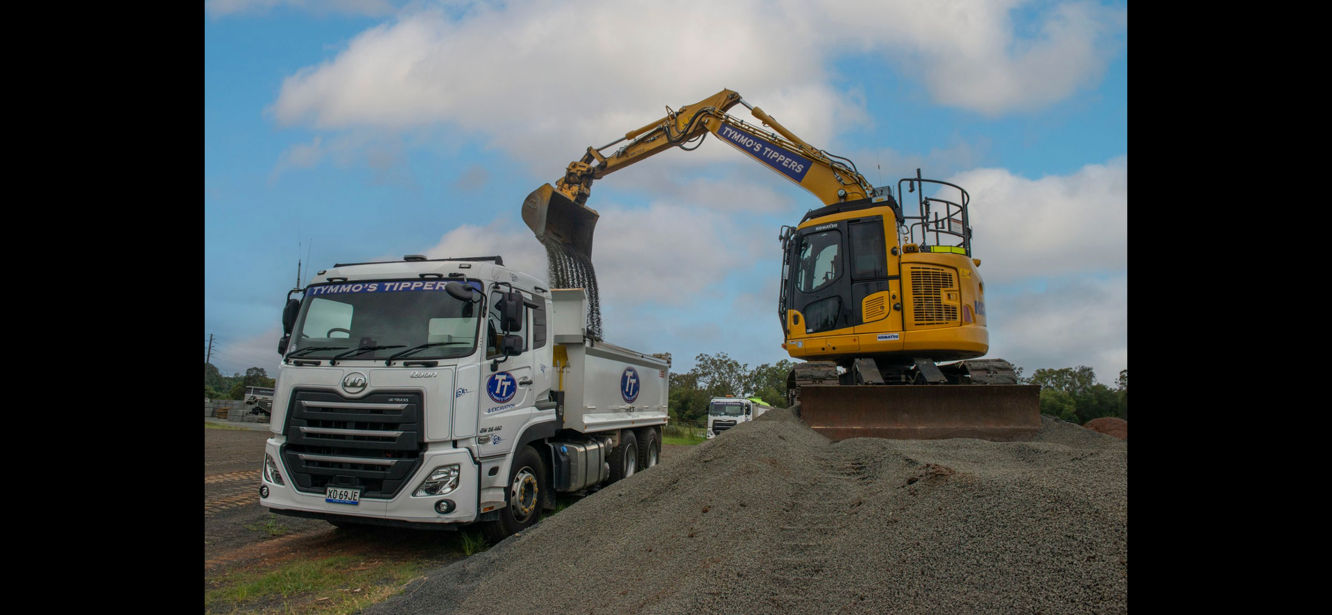 A Dump Truck And An Excavator Are Parked In A Grassy Field — Tymmo's Tippers In West Ballina, NSW