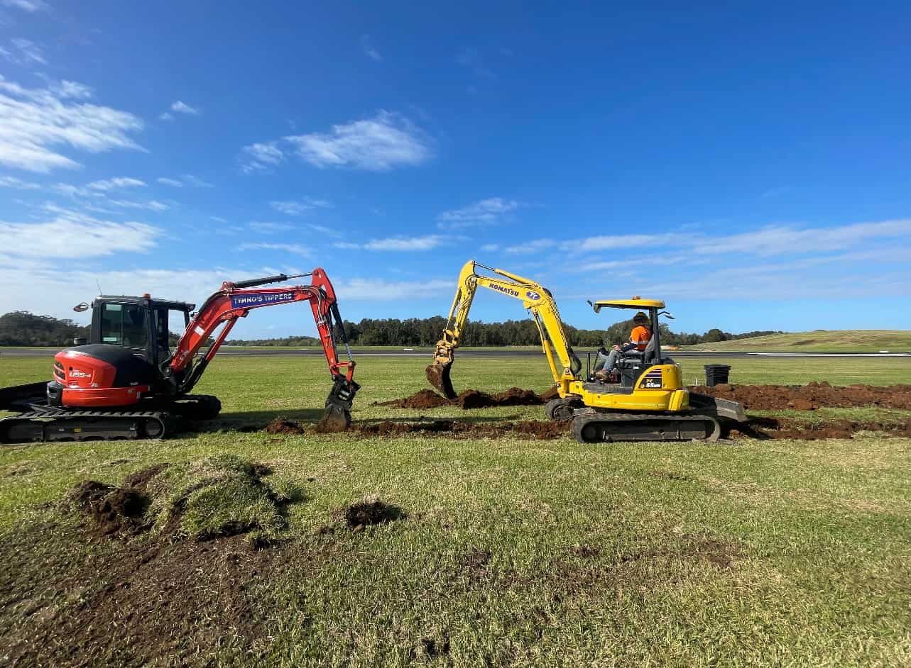 Two Excavators Are Working In A Field On A Sunny Day — Tymmo's Tippers In Byron Bay, NSW