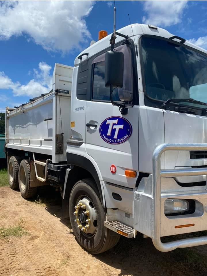 A White Dump Truck With The Letters Tt On The Side Is Parked On A Dirt Road — Tymmo's Tippers In Evans Head, NSW