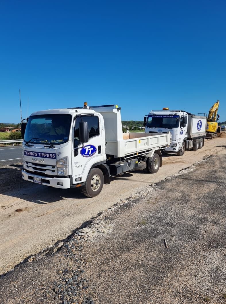 Two Dump Trucks Are Parked On The Side Of A Road — Tymmo's In West Ballina, NSW