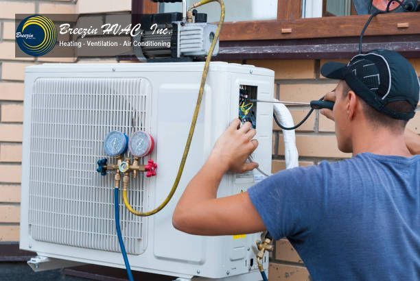 Technician adjusting a wall-mounted air conditioner’s controls with gauges attached outdoors