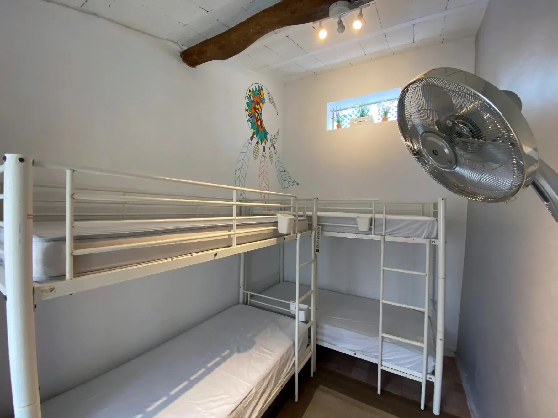 a room with three bunk beds and a fan on the wall .