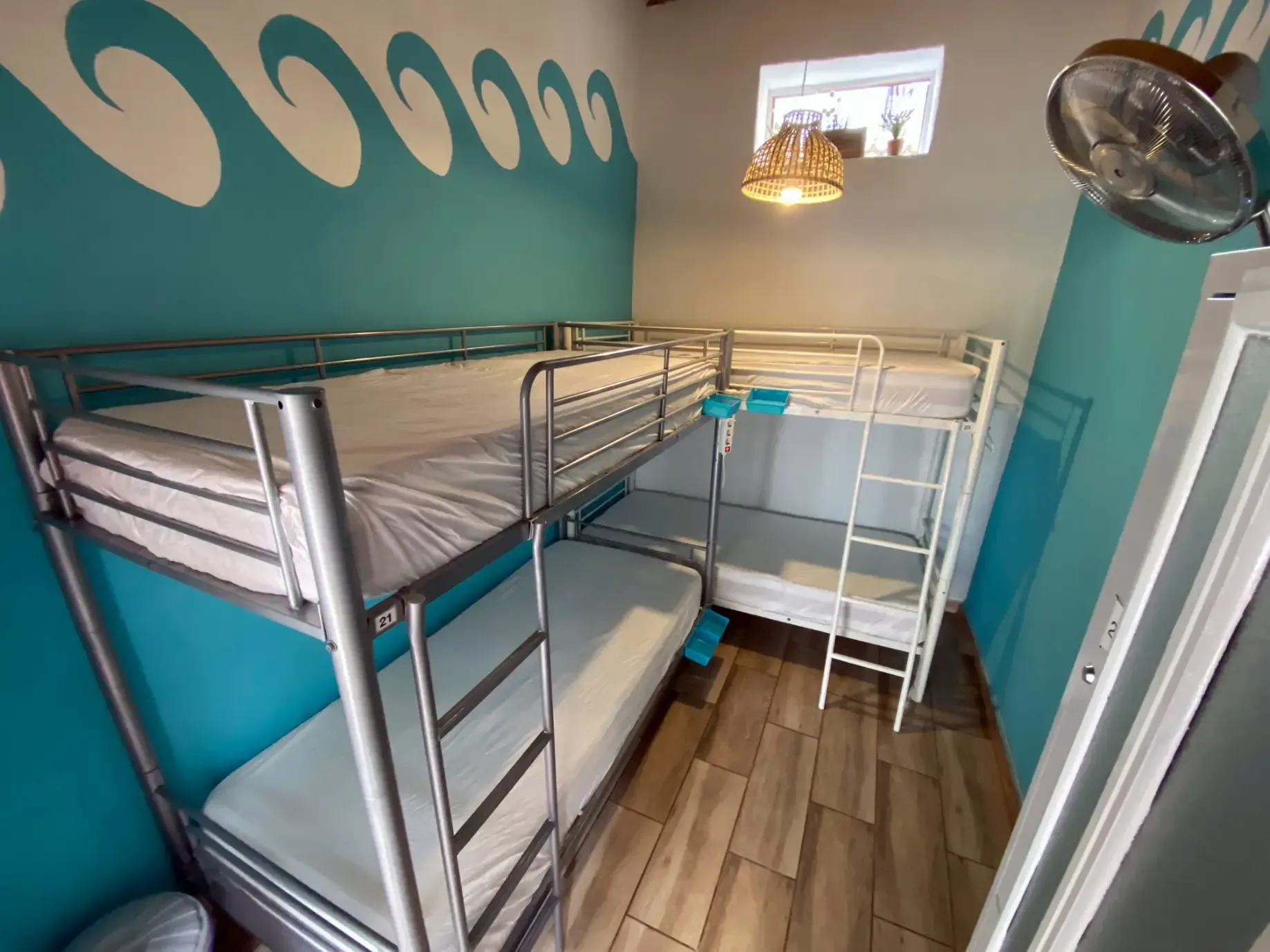 a room with bunk beds and a fan on the wall .