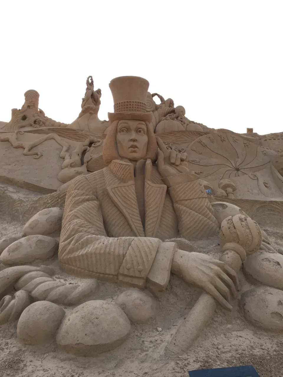 a sand sculpture of a man wearing a top hat
