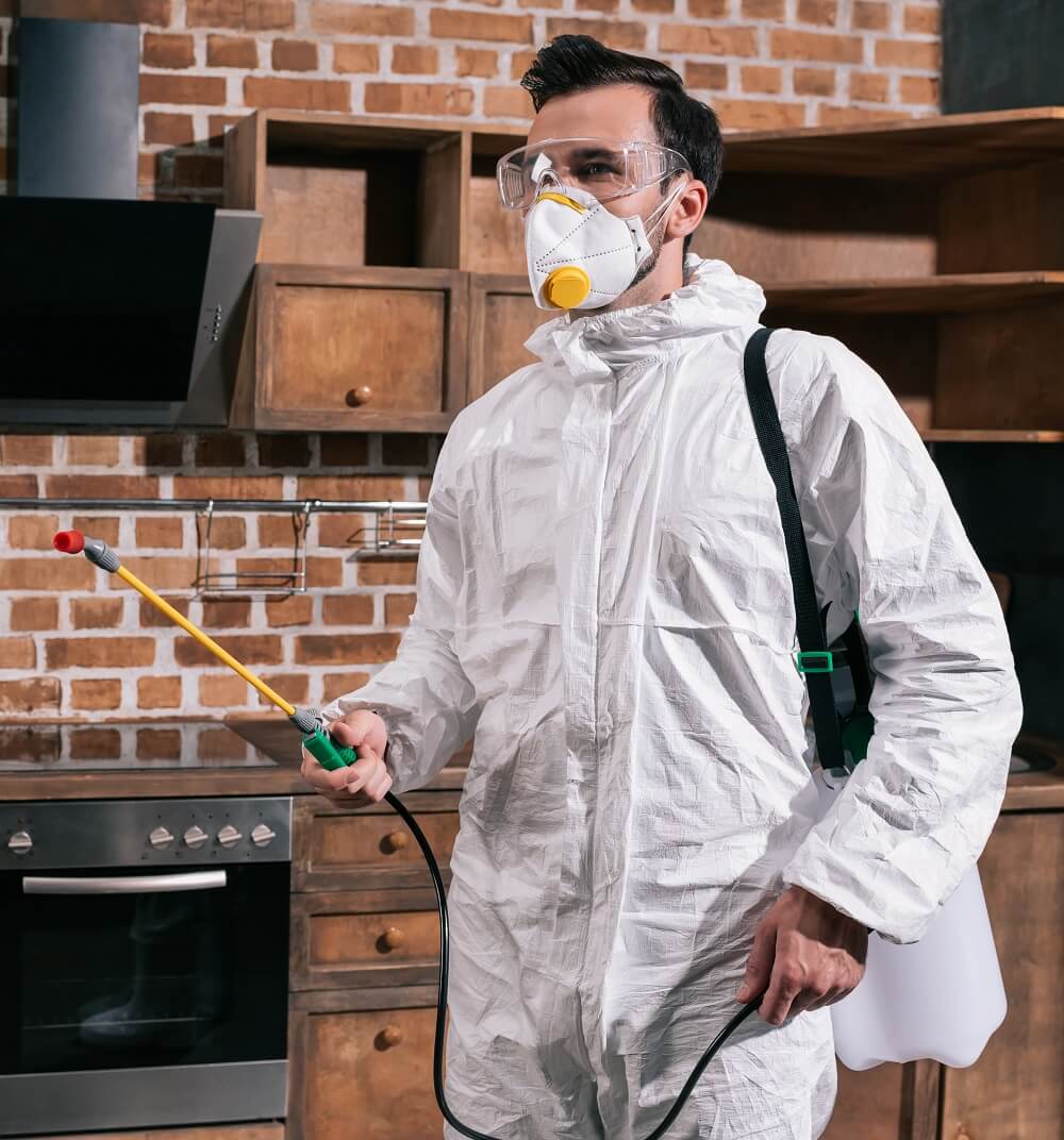 Side view of pest control worker standing with spray