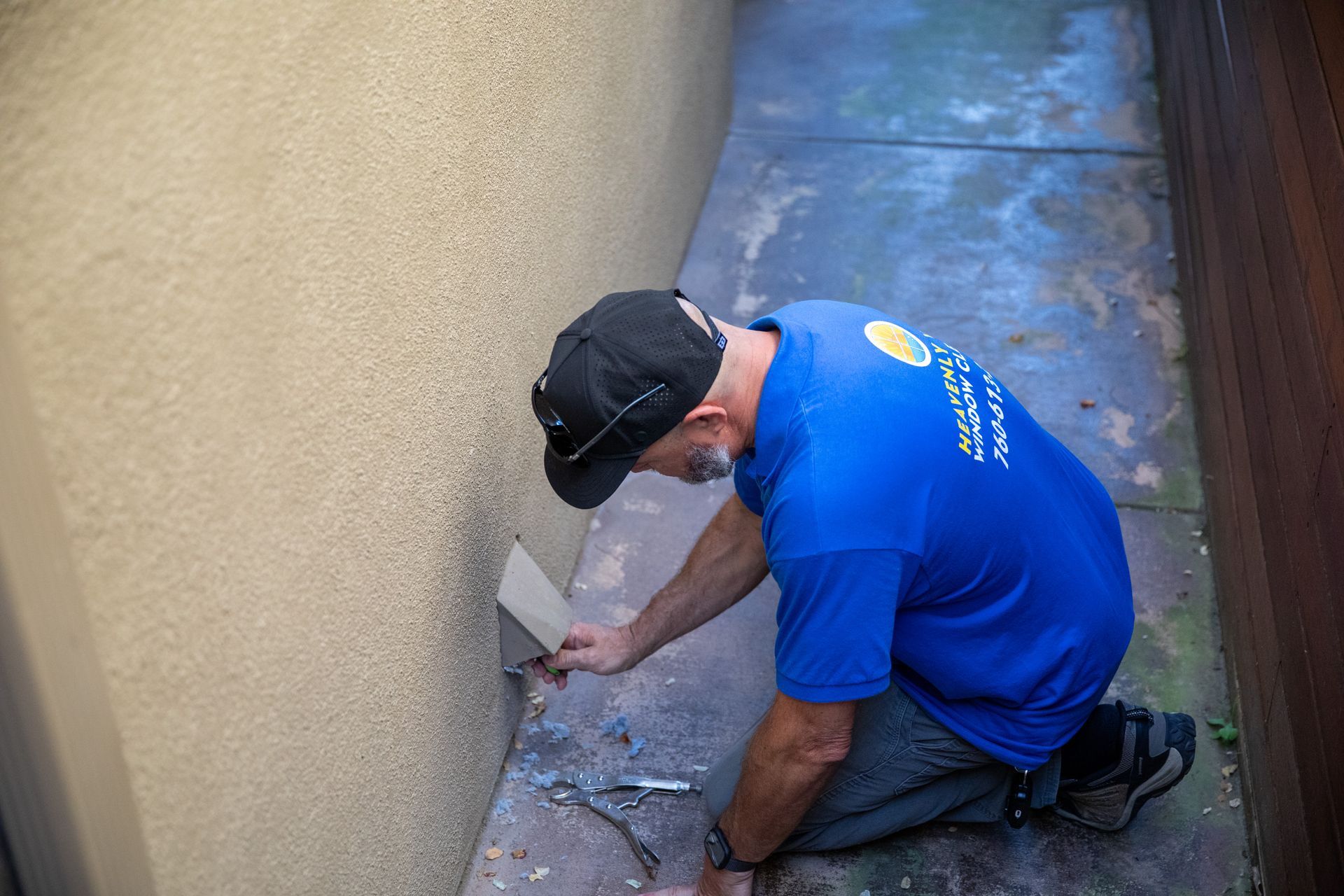 White vent pipe on house siding clogged with gray lint and debris spilling out