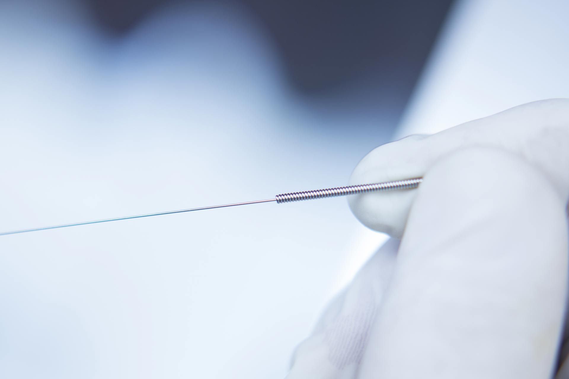 A person is holding an acupuncture needle in their hand.