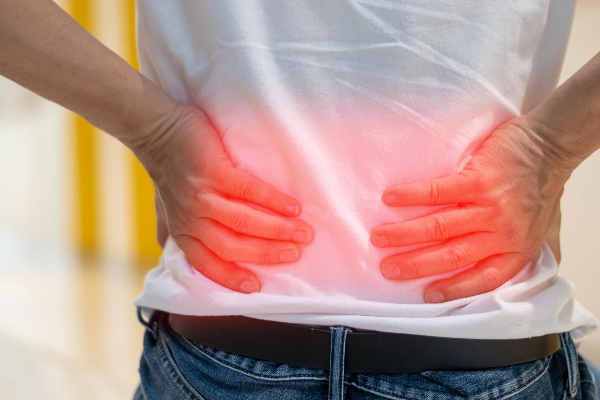 A man is holding his back in pain.