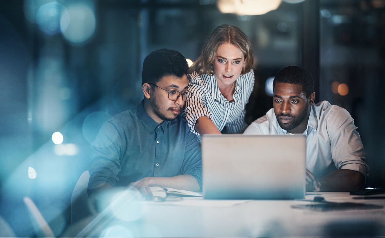 A group of people are looking at a laptop computer.