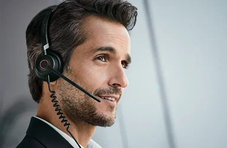 A man with a beard is wearing a headset with a microphone.