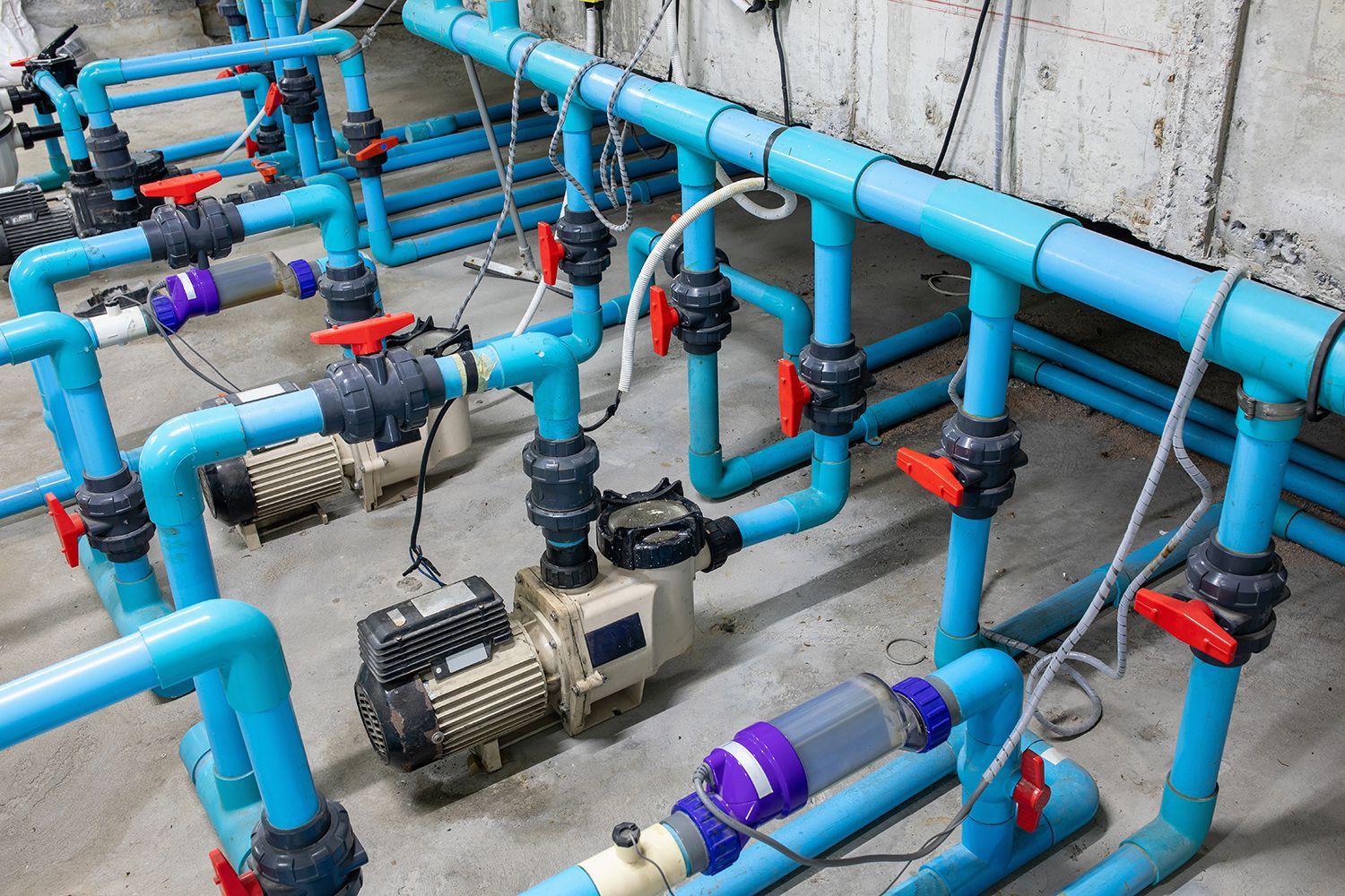 Blue and red industrial pipes with valves and pumps in a mechanical utility system Blue and red industrial pipes with valves and pumps in a mechanical utility system