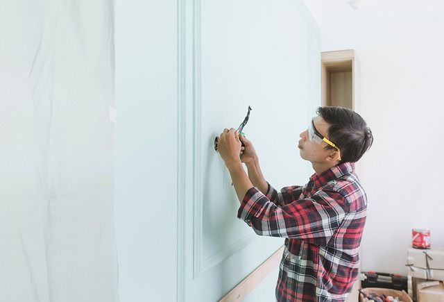 Maintenance man inspecting and working on electrical wiring with safety glasses