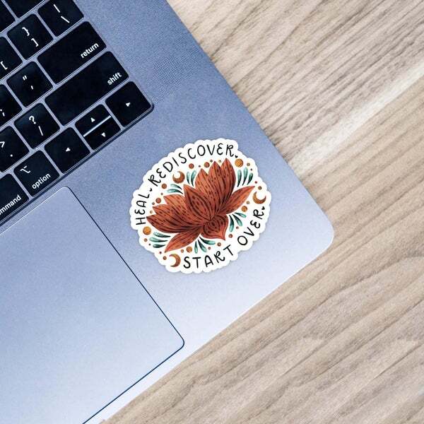 a laptop with a sticker that says heal rediscover start over