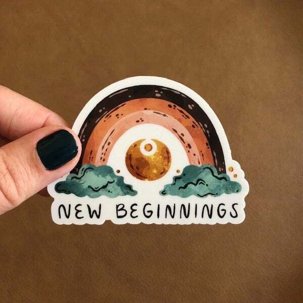 a person is holding a sticker that says new beginnings