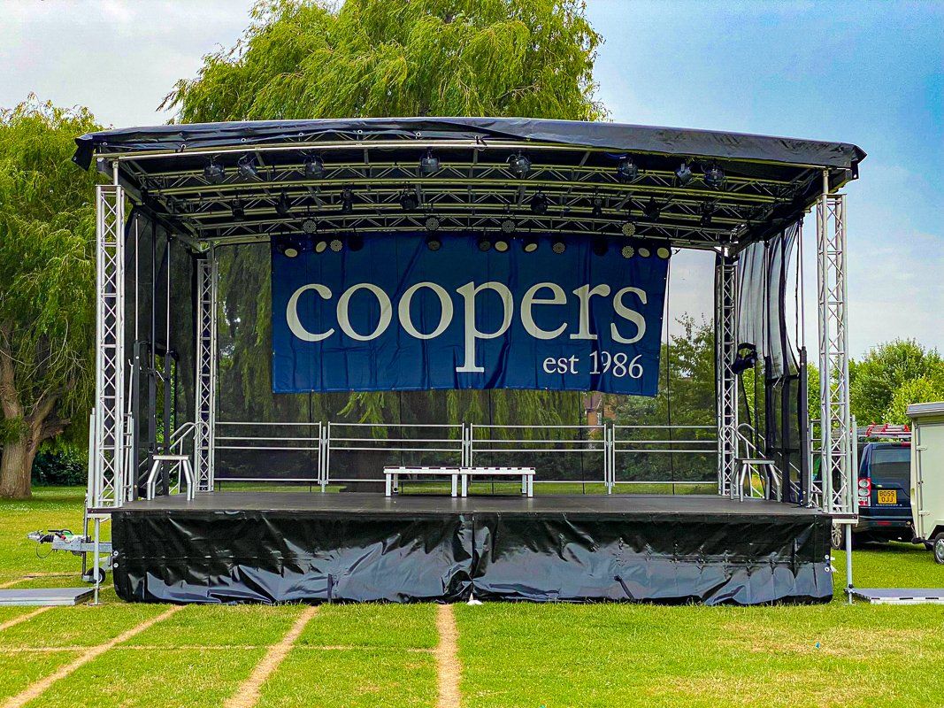 Trailer stage set up for an outdoor event with branding on the back