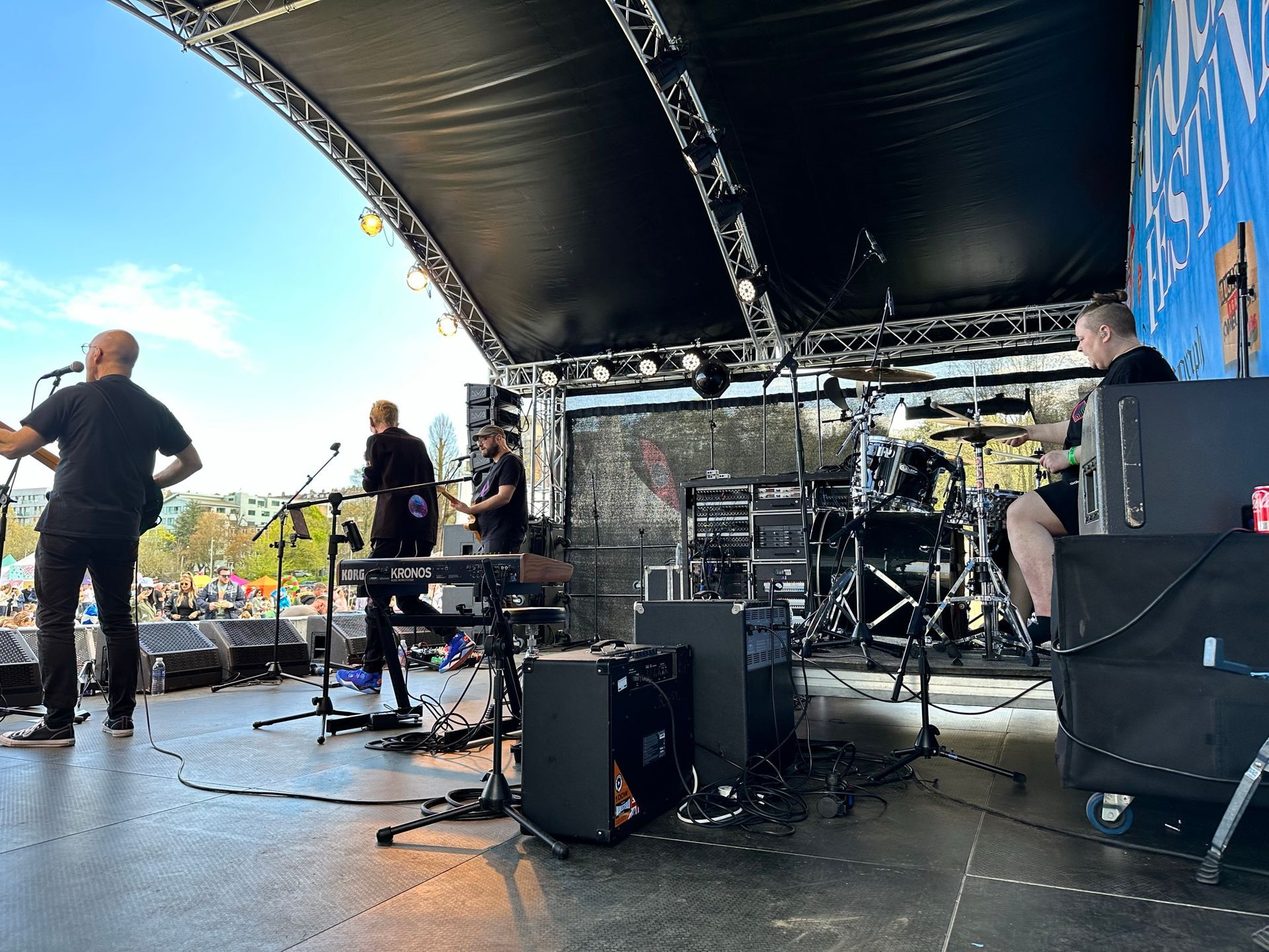 A shot from inside an arc truss stage where a band is performing with lots of kit and equipment.