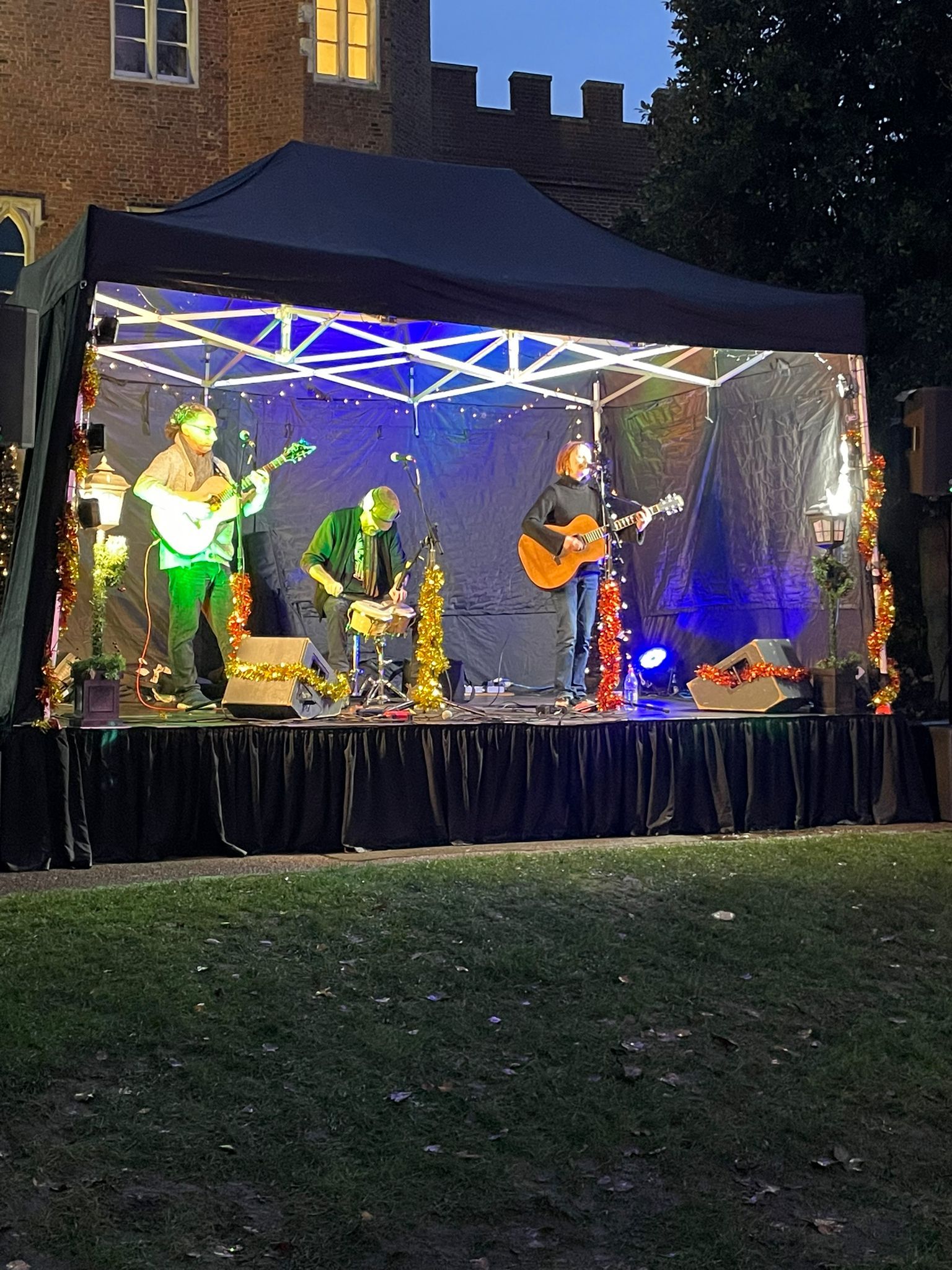 Nighttime shot of a band playing on modular stage in front of Hertford Castle