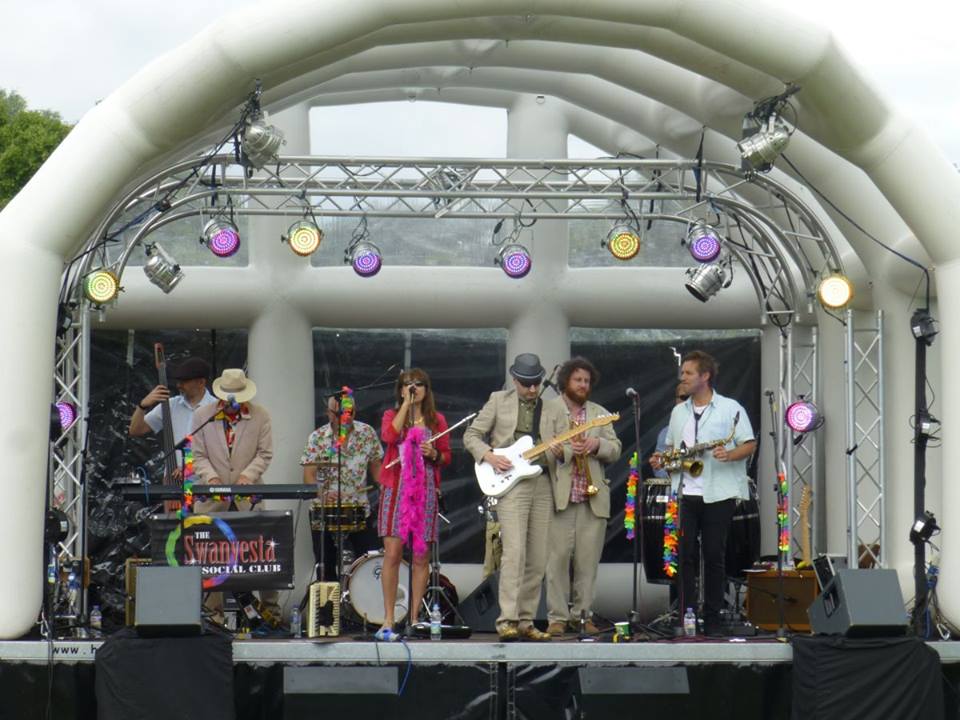 full band performing on a stage with inflatable roof