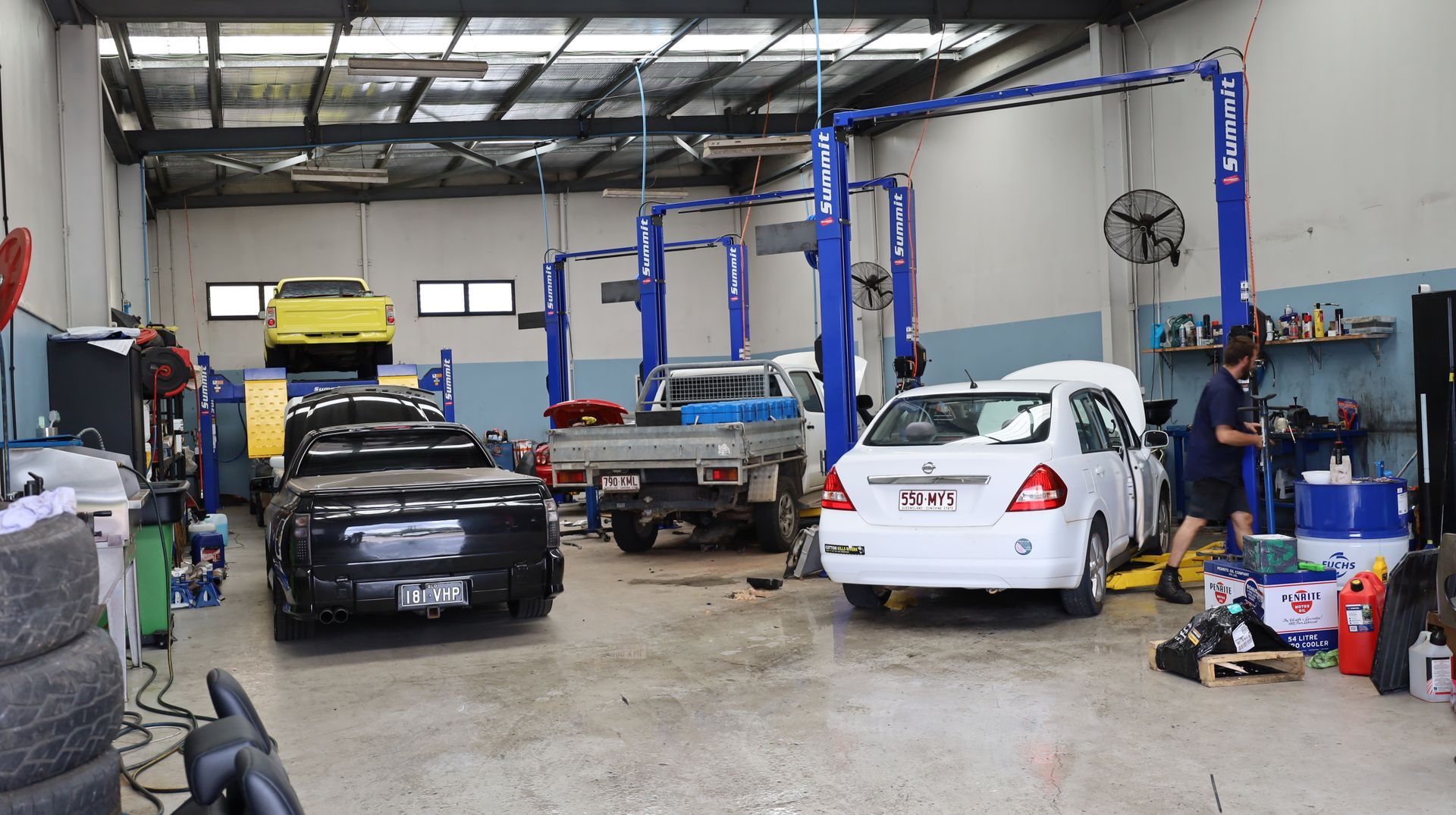 Auto Repair Garage with Cars on Lifts, a Black Car in Front, and Tools and Equipment Around the Shop — Mad Monkeys Mechanical in Cairns City, QLD