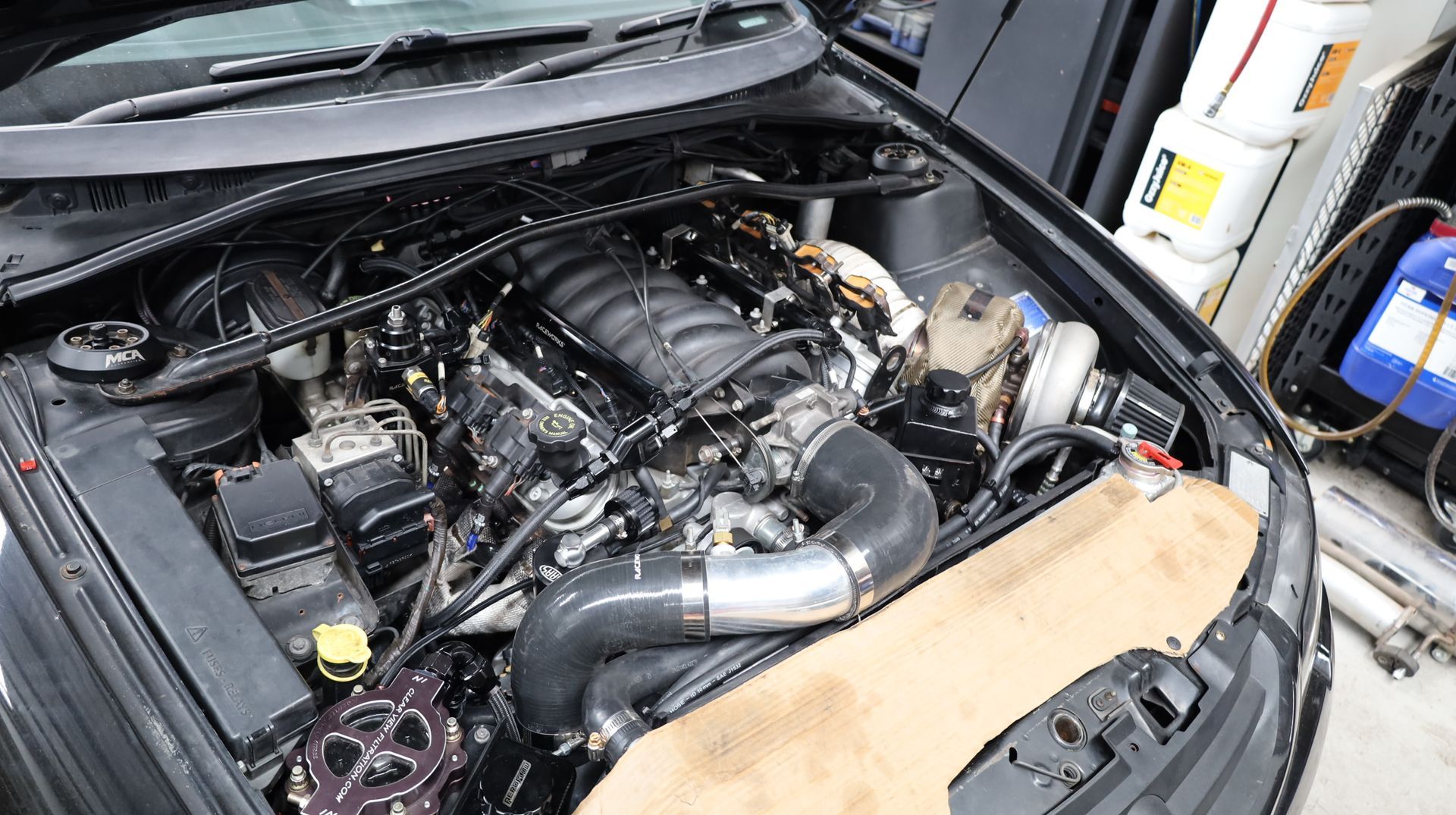 Car Engine Bay with a Modified Intake and Exposed Components Under the Open Hood — Mad Monkeys Mechanical in Cairns City, QLD