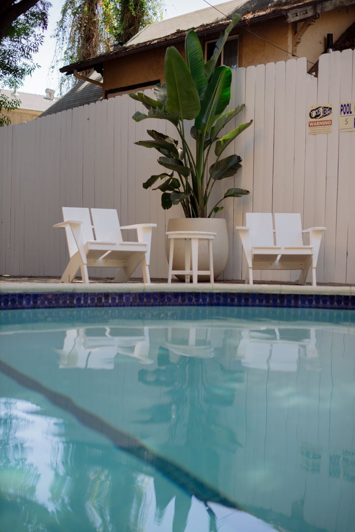 A swimming pool with chairs and tables next to it