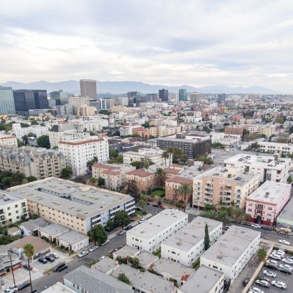 Cityscape: Downtown buildings, apartment complexes, and surrounding area under a cloudy sky.