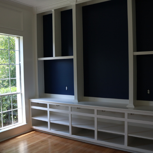 An empty room with blue walls and white shelves